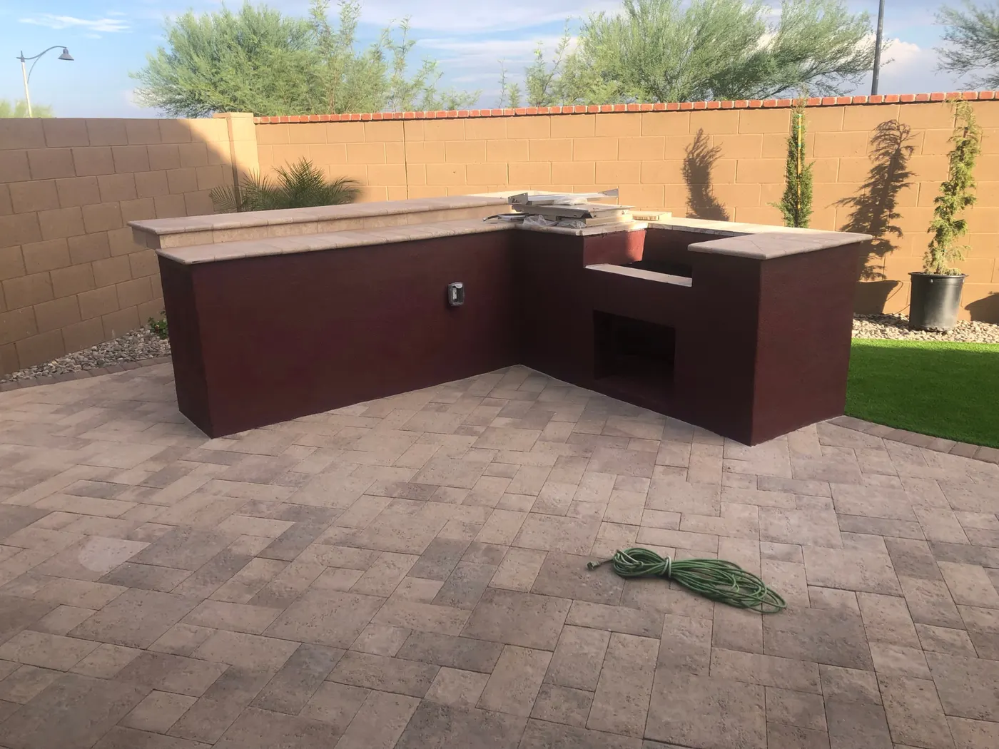 Deep burgundy painted outdoor kitchen surround on a Phoenix patio